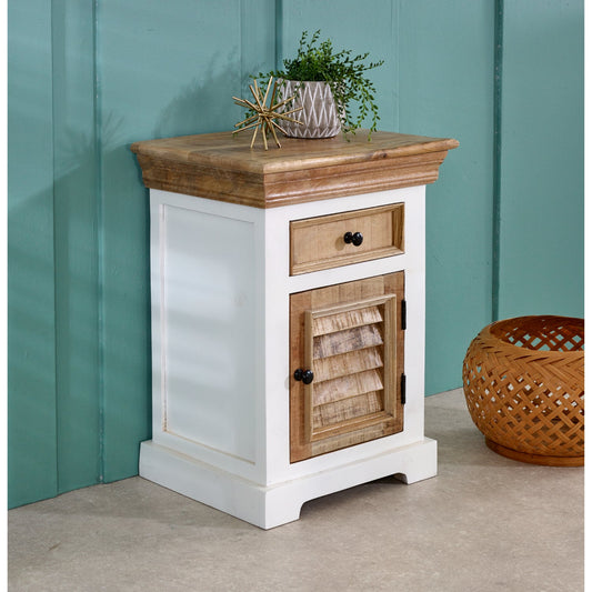Wooden side table with white base and wooden top against a teal wall.