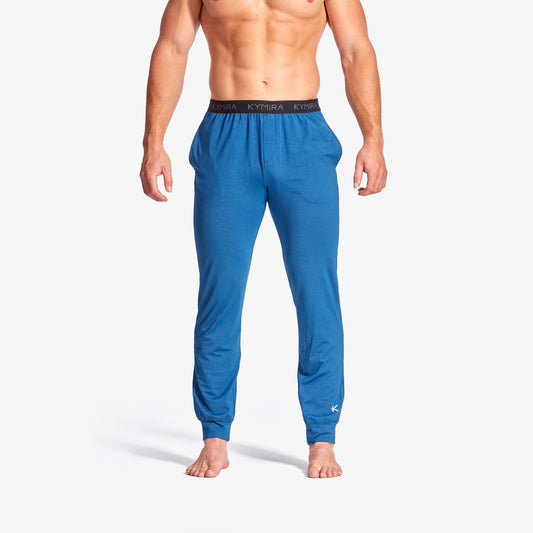 Man wearing blue pajama pants on a white background