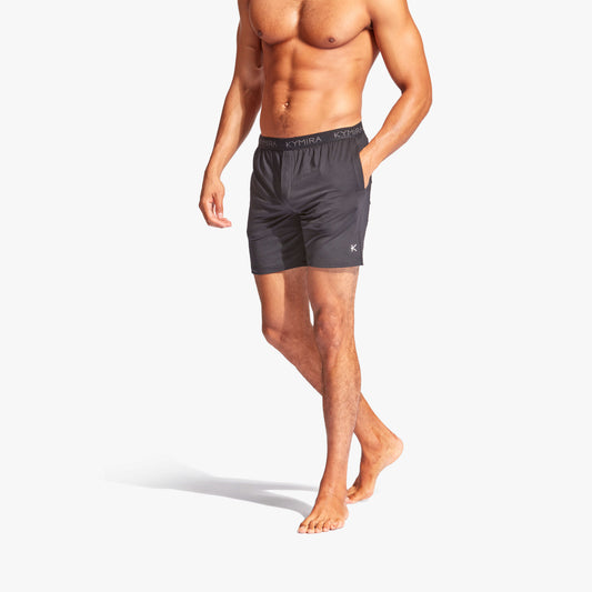 Man wearing dark gray shorts on a white background