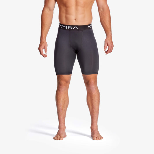 Person wearing black compression shorts with a visible brand logo on a white background