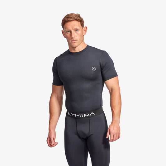 Man wearing a black Kymira athletic outfit on a white background