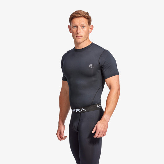 Man wearing a black athletic outfit with a visible brand logo on a white background