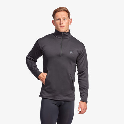 Man wearing a dark gray long-sleeve athletic shirt with a logo on a white background