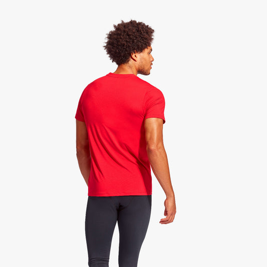 Person wearing a red t-shirt and black leggings on a white background