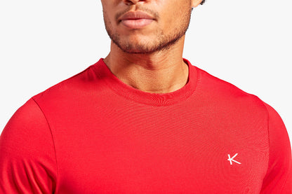 Red athletic shirt with a logo on a white background