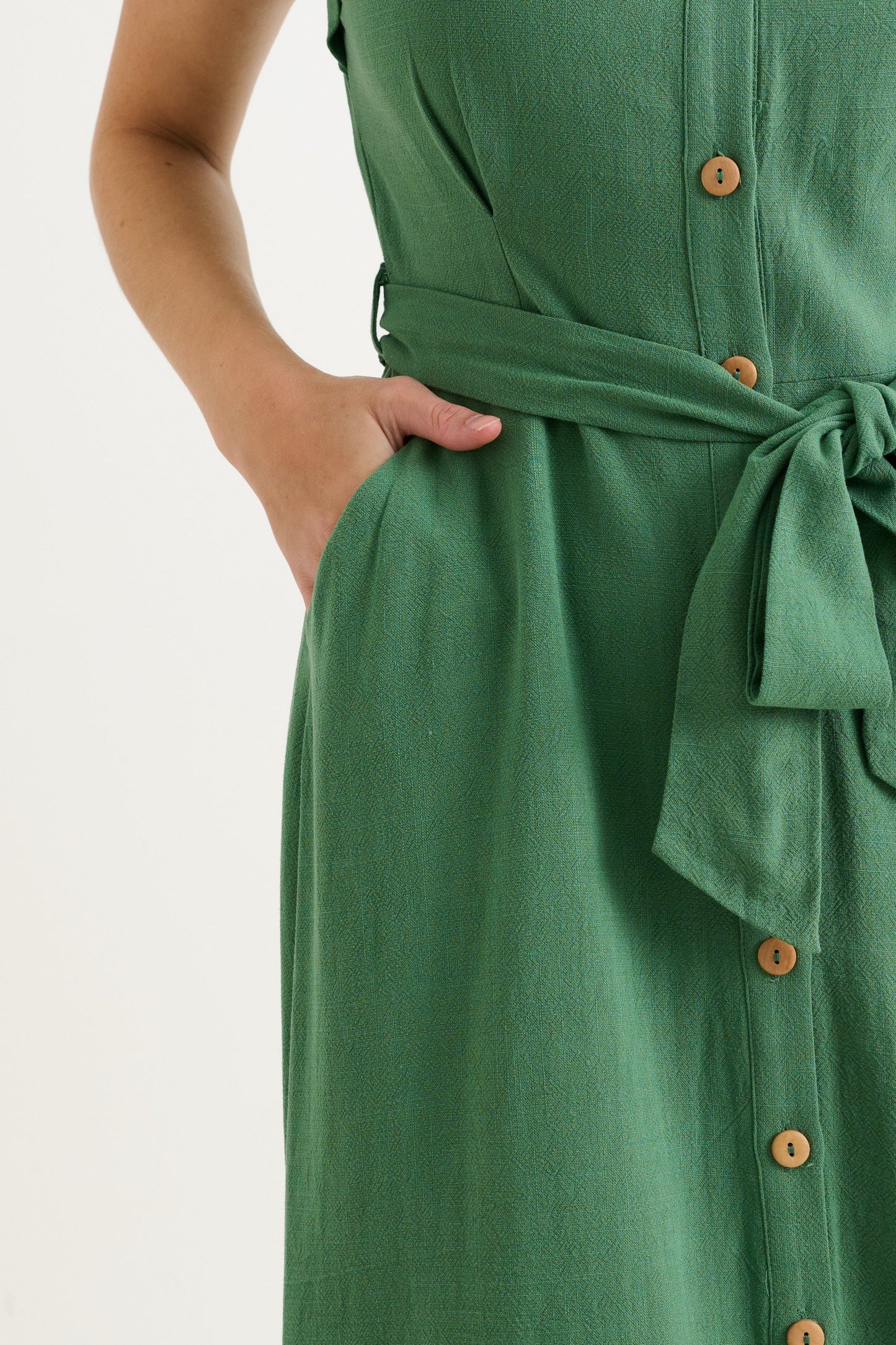 Green dress with buttons and a belt on a white background