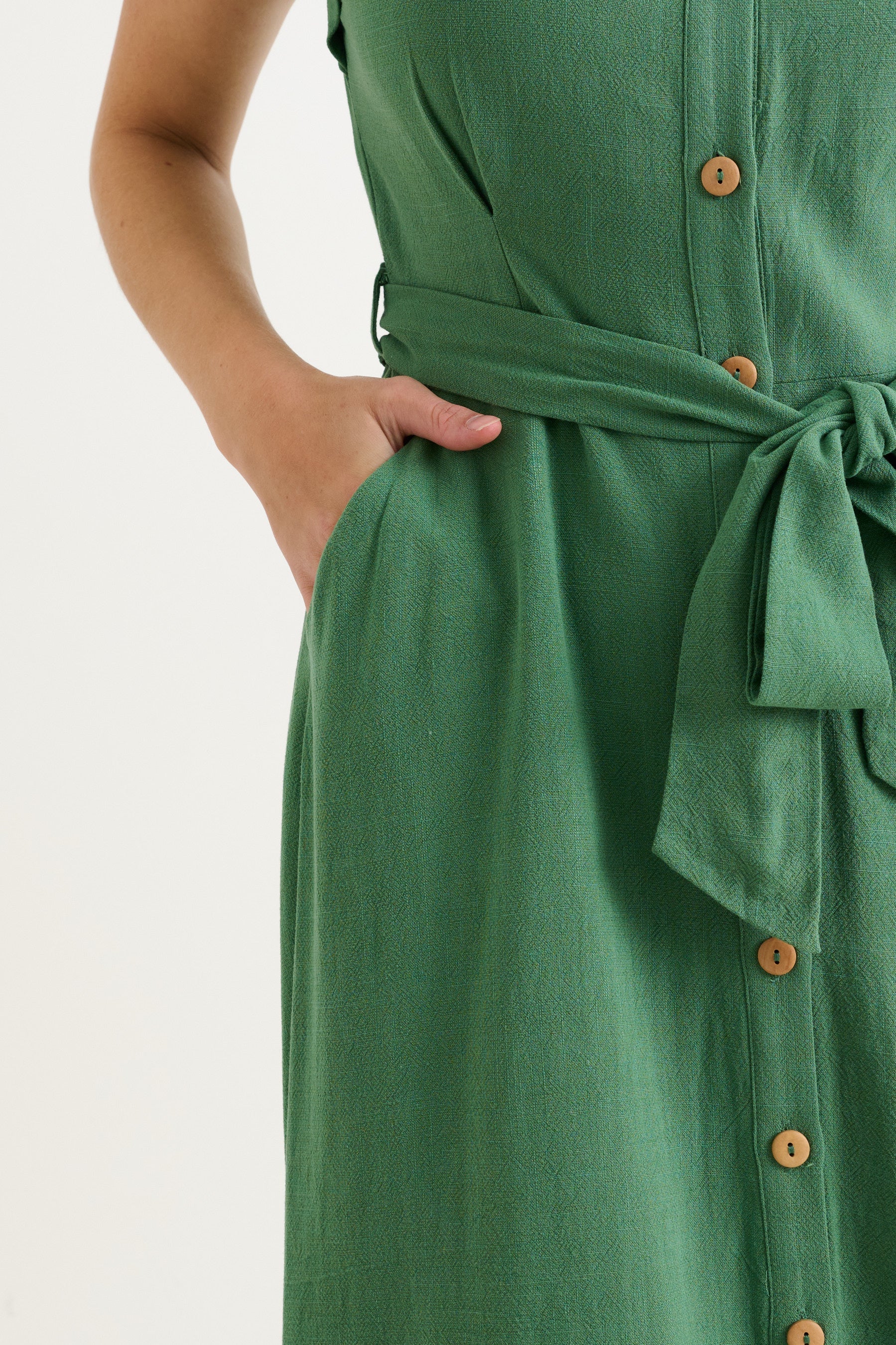 Green dress with buttons and a belt on a white background