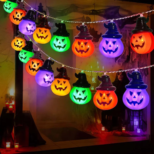 String of colorful Halloween lights shaped like jack-o'-lanterns on a dark background.