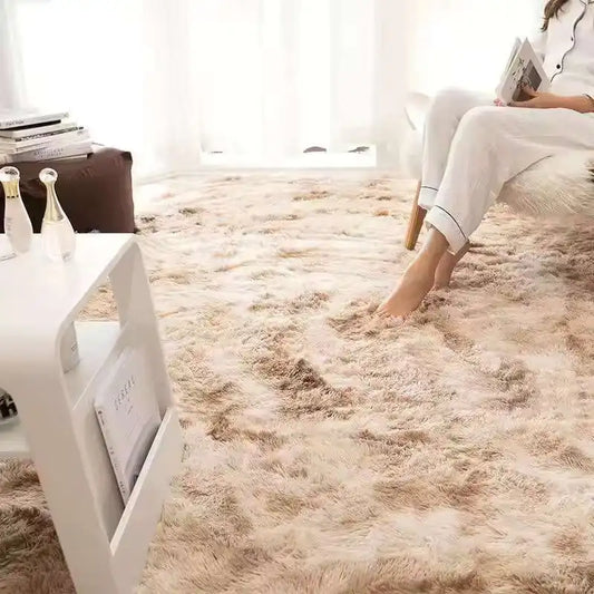 Person sitting on a fluffy rug in a living room with a coffee table and books.