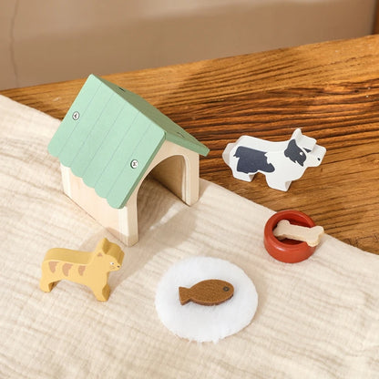Wooden toy set with a house, animals, and food on a wooden surface.