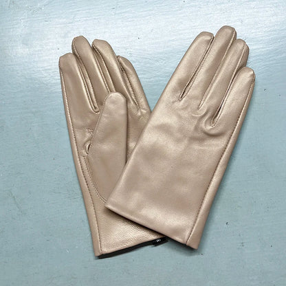 Pair of beige leather gloves on a light blue background