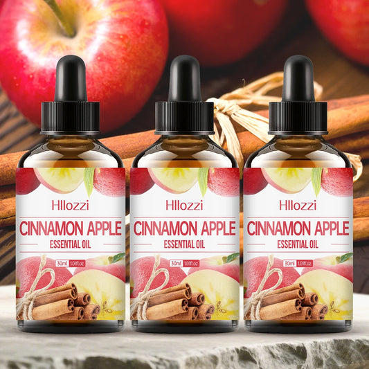 Three bottles of Hilozzi Cinnamon Apple Essential Oil with apples and cinnamon sticks in the background.