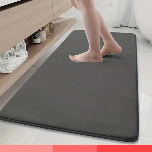 Gray bath mat on a bathroom floor with text highlighting features