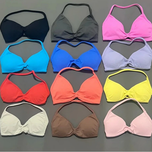 Collection of colorful bikini tops on a gray background