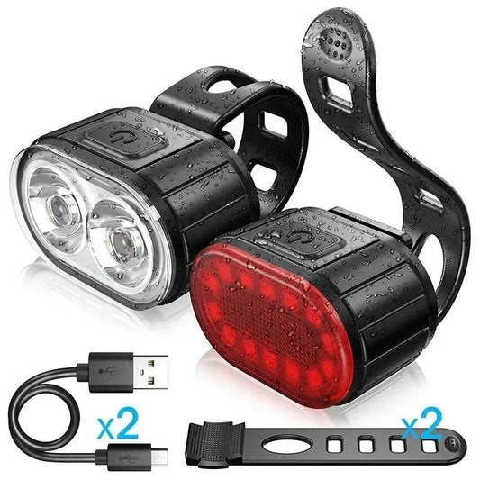 Bicycle lights set with front and rear lights, USB cable, and reflectors on a white background