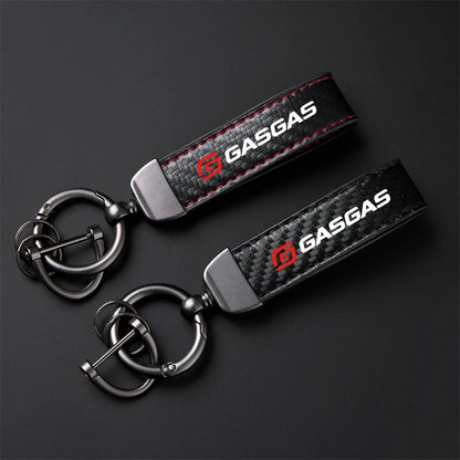 Two GasGas branded keychains on a dark background
