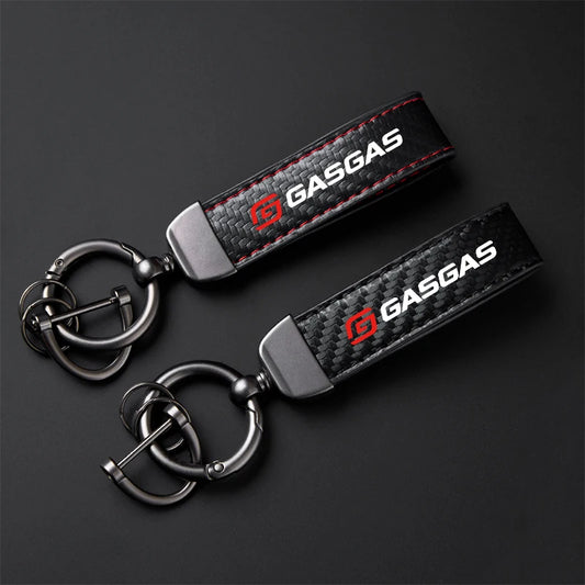 Two GasGas branded keychains on a dark background