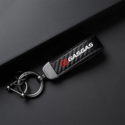 Carbon fiber keychain with 'GASGAS' logo on a dark background