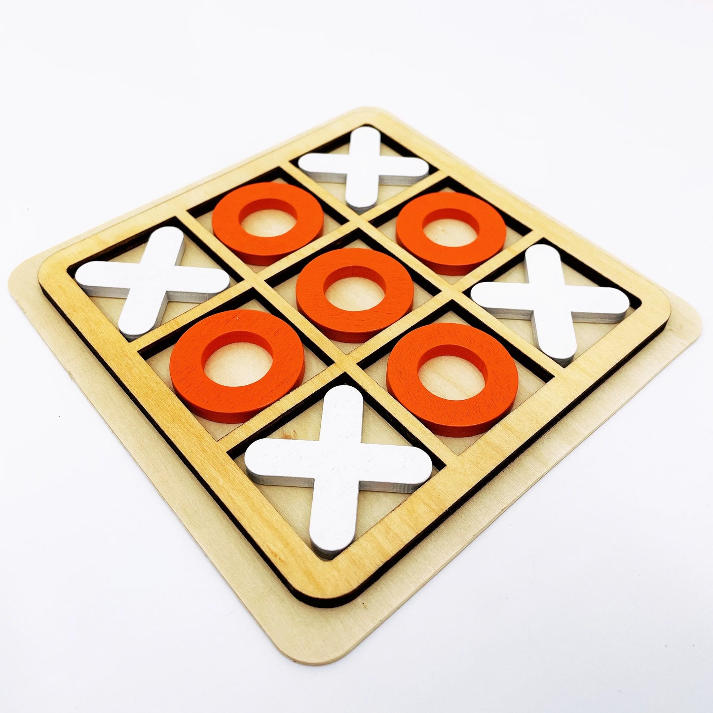 Wooden tic-tac-toe game with red and white pieces on a white background
