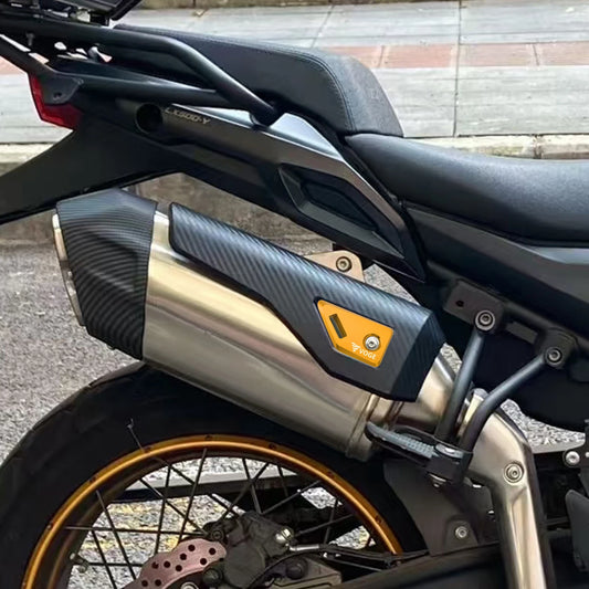 Close-up of a motorcycle exhaust with a visible brand logo on a blurred background