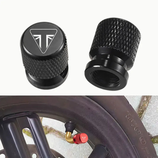 Two black valve stem caps with a logo on a white background, one cap is shown on a tire.