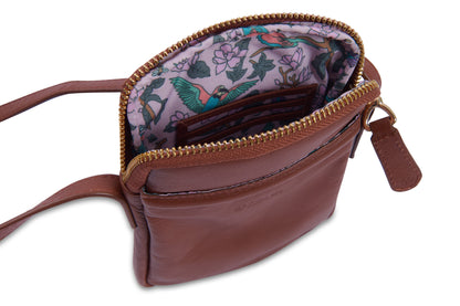Brown leather crossbody bag with floral interior on a white background