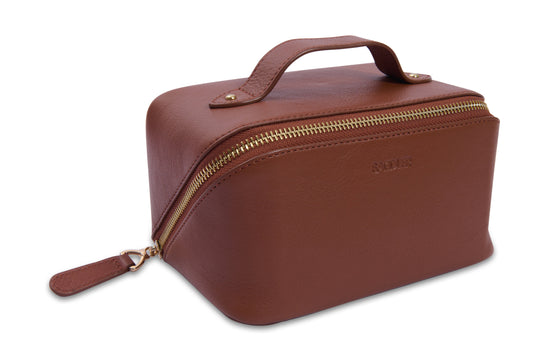 Brown leather toiletry bag with gold zipper on a white background