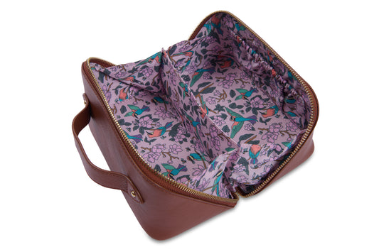 Brown leather bag with floral interior lining on a white background