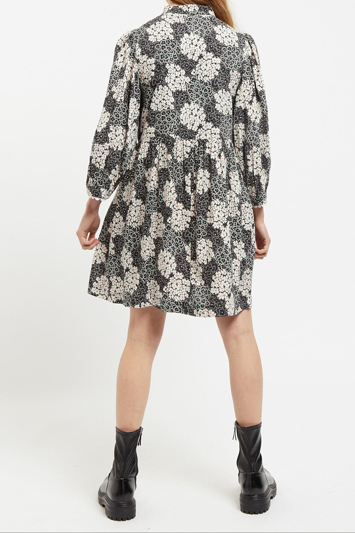 Person wearing a black and white floral dress on a white background