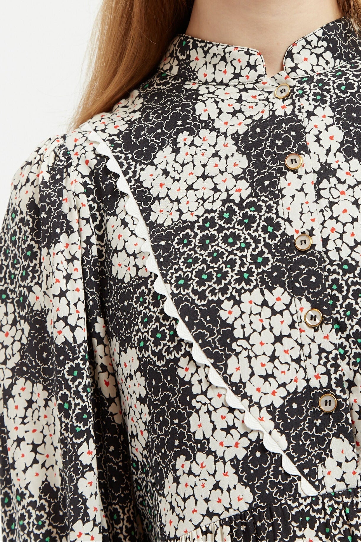Close-up of a floral patterned blouse with black, white, and beige colors.