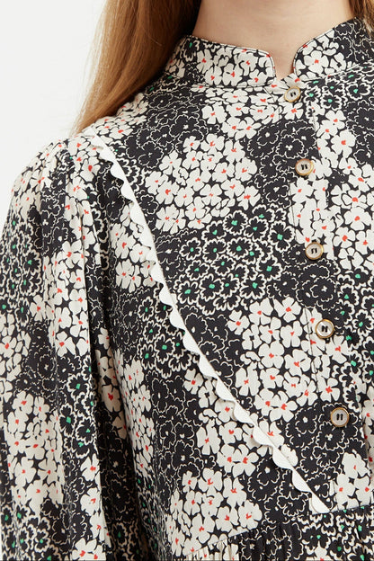 Close-up of a floral patterned blouse with black, white, and beige colors.