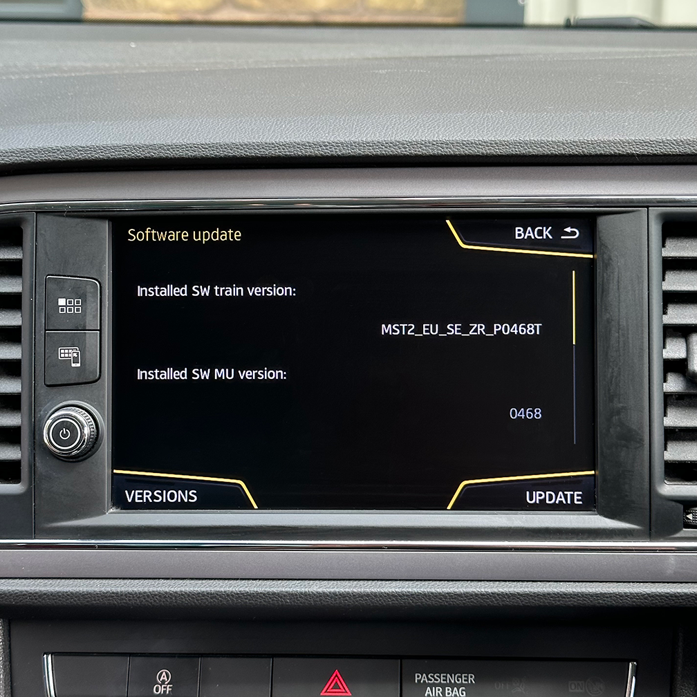 Car dashboard with a digital display showing software update information.