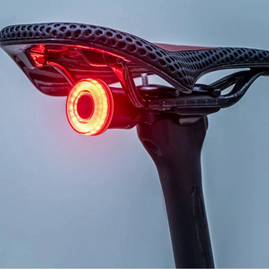 Bicycle saddle with built-in red light on a gray background, featuring the RockBros brand.