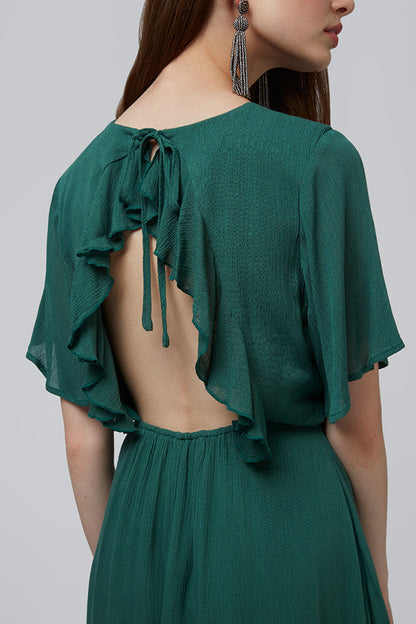 Green dress with ruffled sleeves and open back on a plain background