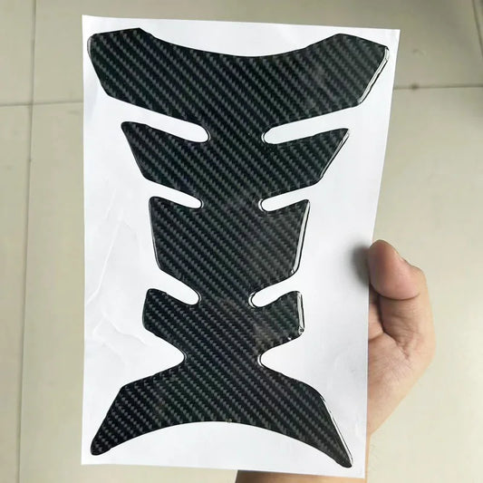 Carbon fiber patterned decal on a white background held by a hand.