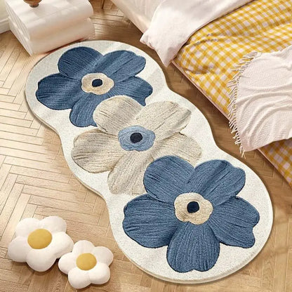 Floral-patterned rug with blue and beige flowers on a wooden floor.