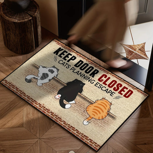 Doormat with cartoon cats and text 'Keep door closed, cats planning escape' on a wooden floor.