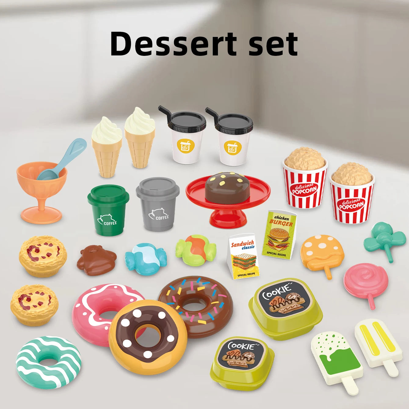 Set of toy desserts and dining items on a white surface with 'Dessert set' text above.