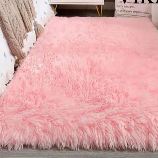 Pink fluffy rug on a wooden floor