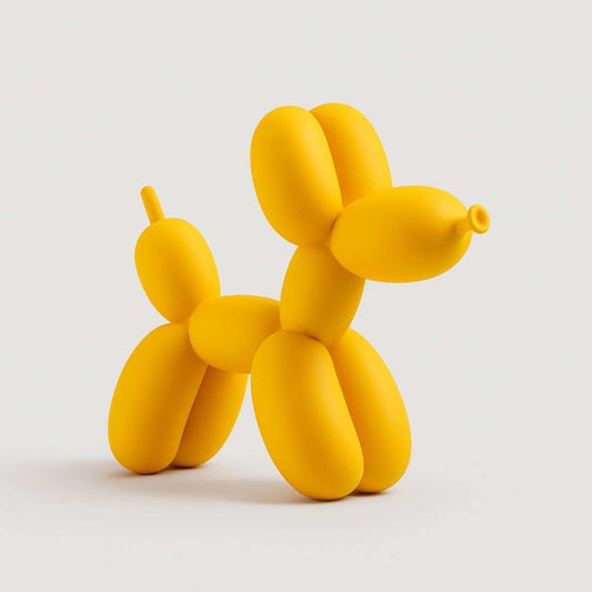 Yellow balloon dog sculpture on a light gray background