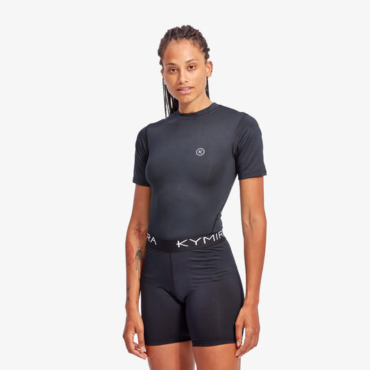 Person wearing a black athletic outfit with 'Kymia' branding on a white background