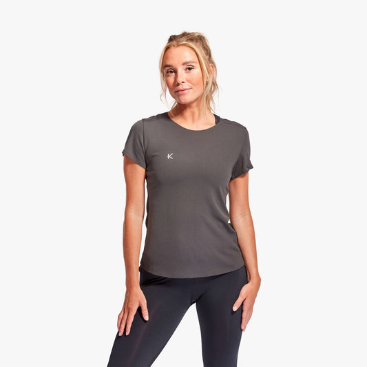 Woman wearing a gray athletic shirt with a logo on a white background