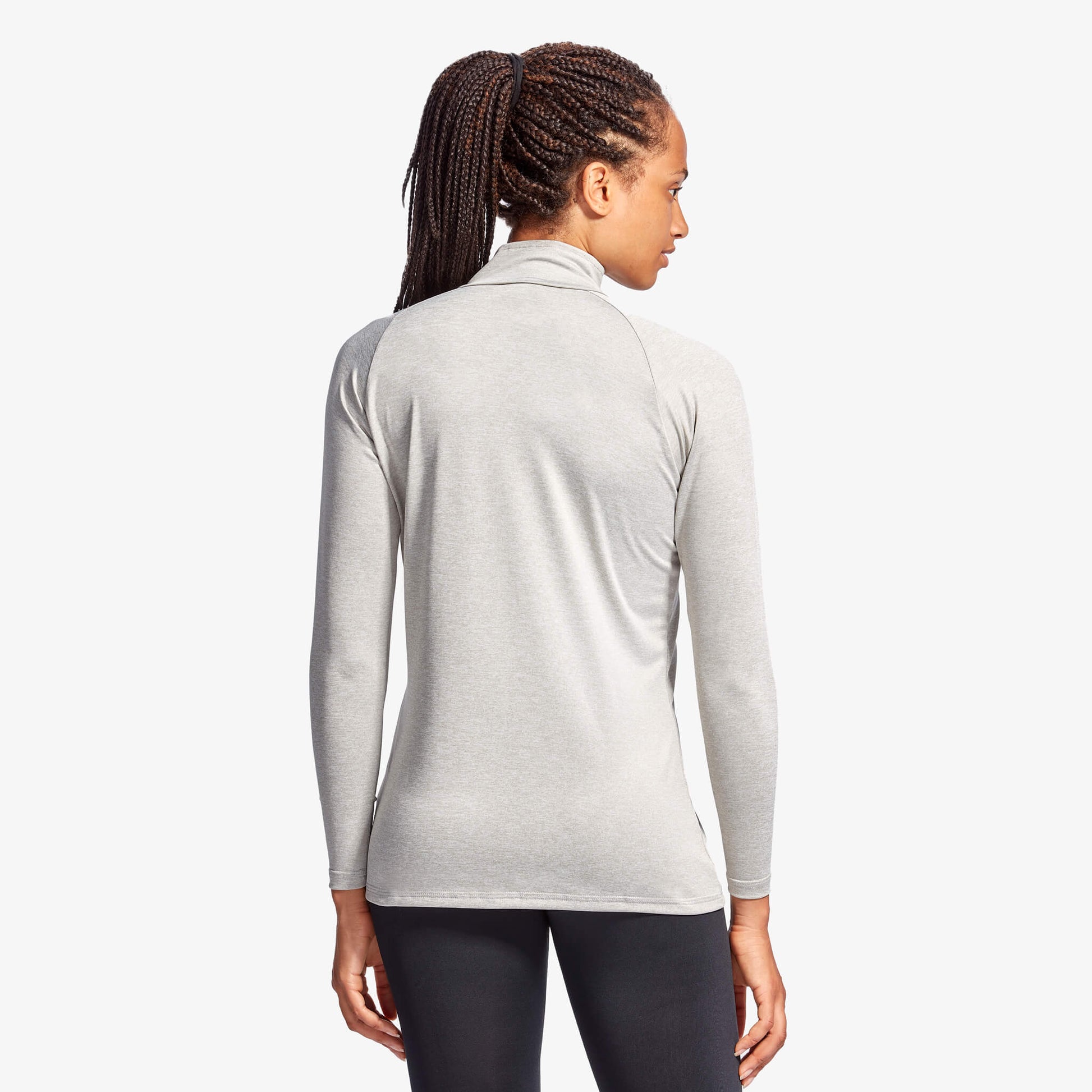 Person wearing a gray long-sleeve athletic top on a white background