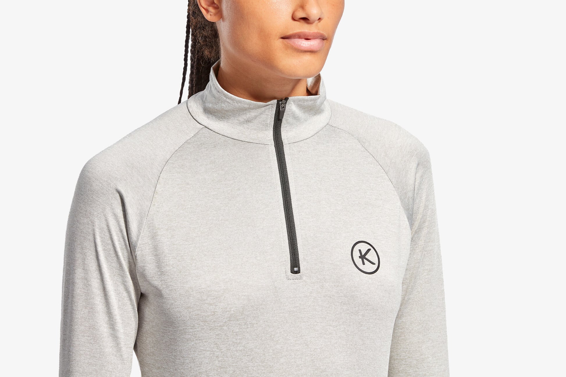 Person wearing a gray quarter-zip sweatshirt with a brand logo on a white background