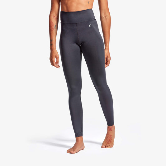 Person wearing dark gray leggings on a white background