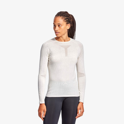 Woman wearing a white long-sleeve athletic shirt on a white background