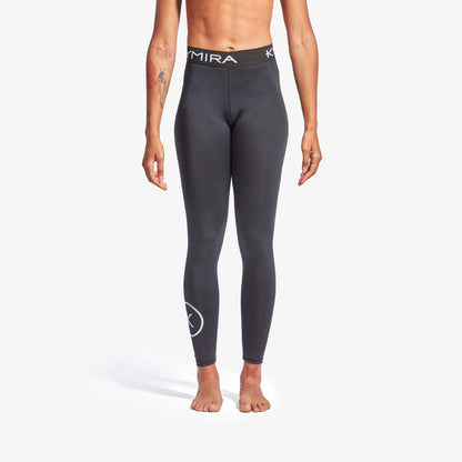 Person wearing dark gray leggings with a brand logo on a white background