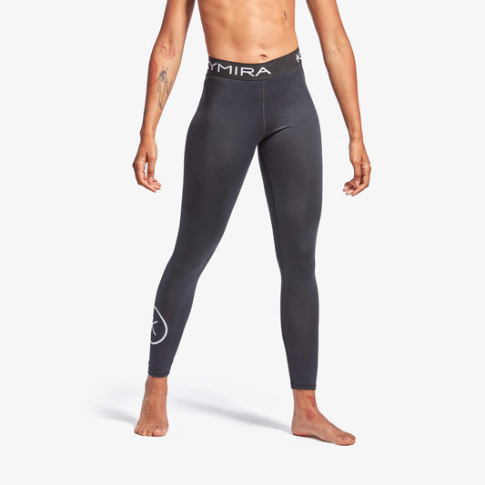 Person wearing dark gray leggings with a brand logo on a white background