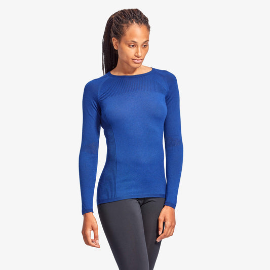 Woman wearing a blue long-sleeve top on a white background