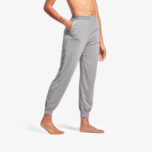 Gray jogger pants worn by a person on a white background